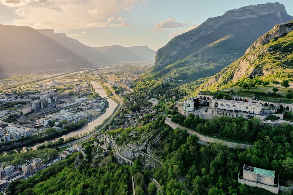 Stunning aerial view of Grenoble cityscape and surrounding mountains at sunset.